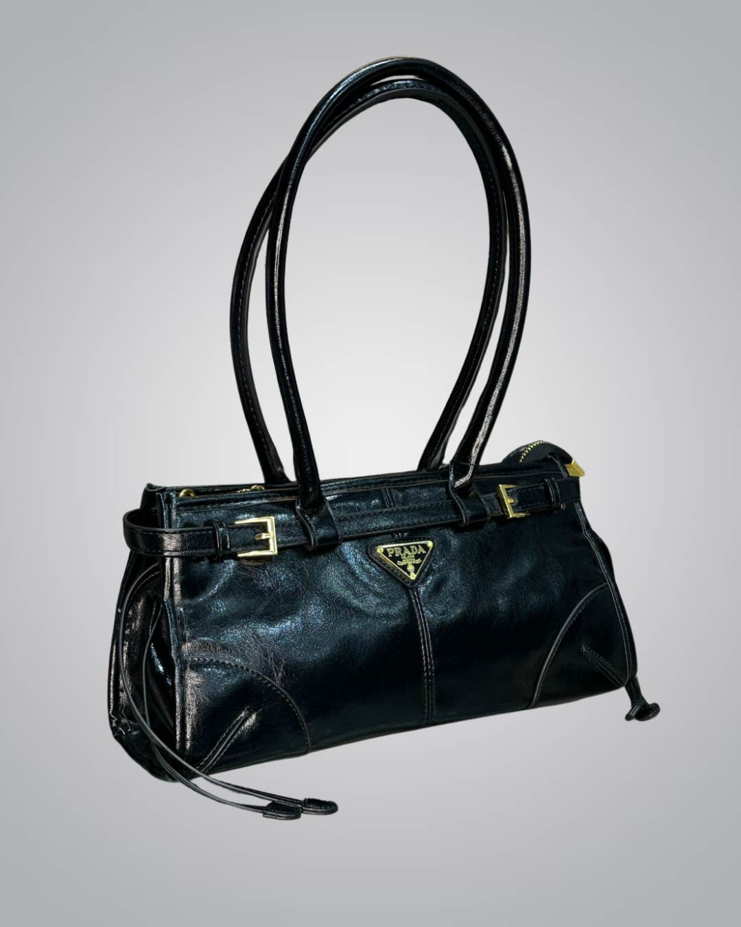 Black handbag with gold accents on a gray background