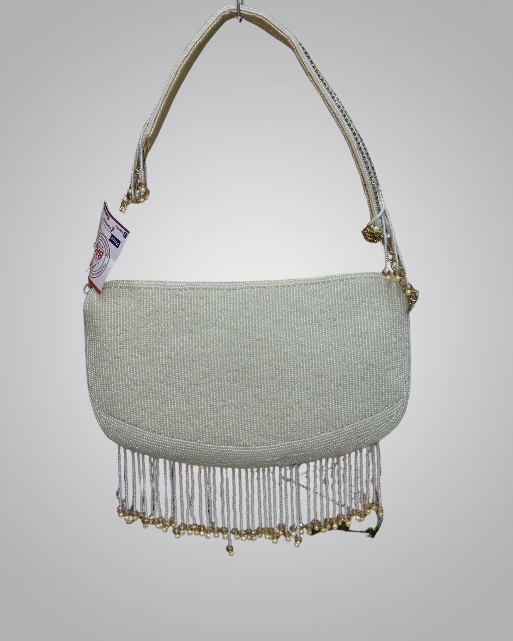 Light green handbag with gold fringe on a gray background
