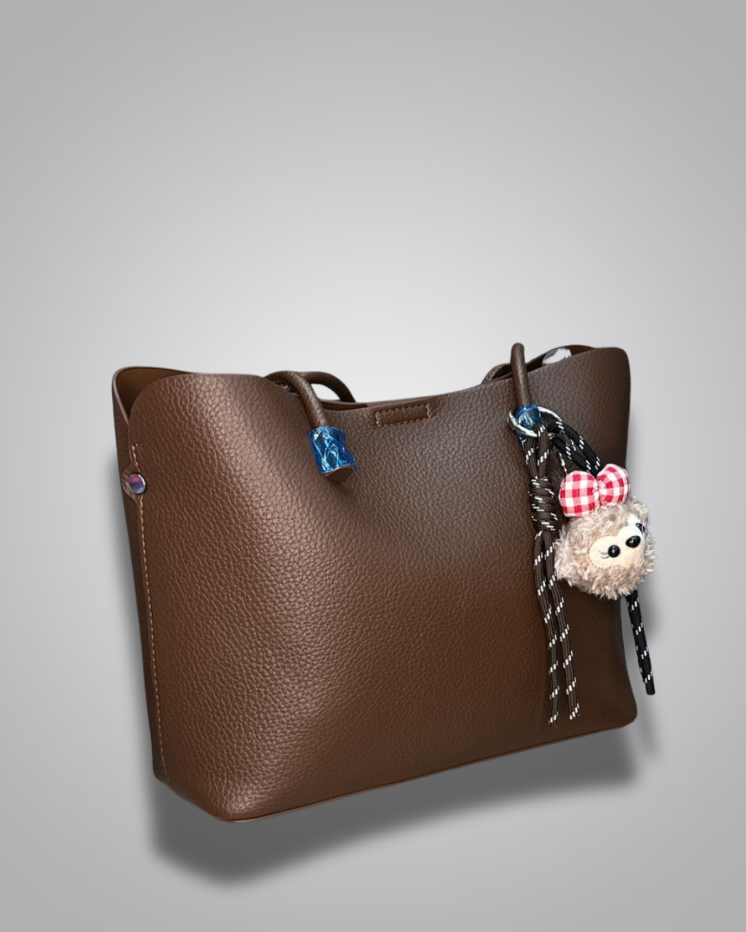 Beige handbag with a sloth keychain on a light gray background- Valentino Impex