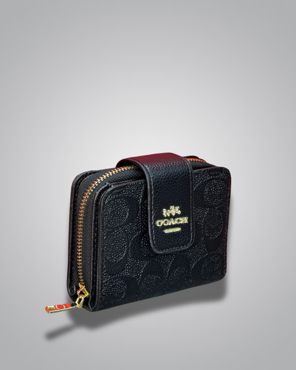Black textured wallet with gold zipper and Coach logo on a gray background