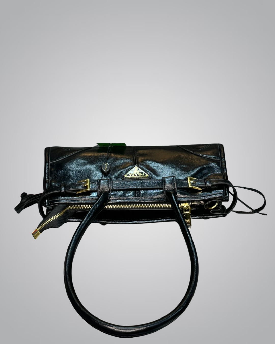 Black handbag with gold accents on a gray background