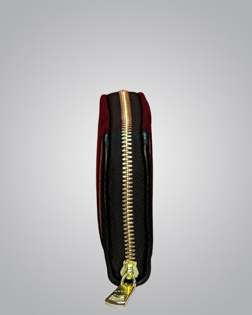 Black pouch with gold zipper on a gray background