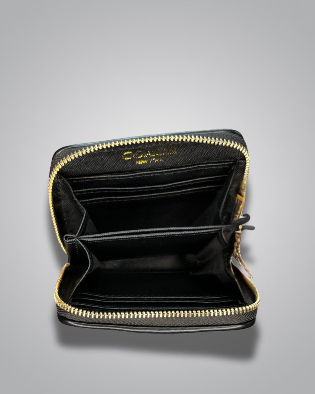 Black wallet with gold zipper on a gray background