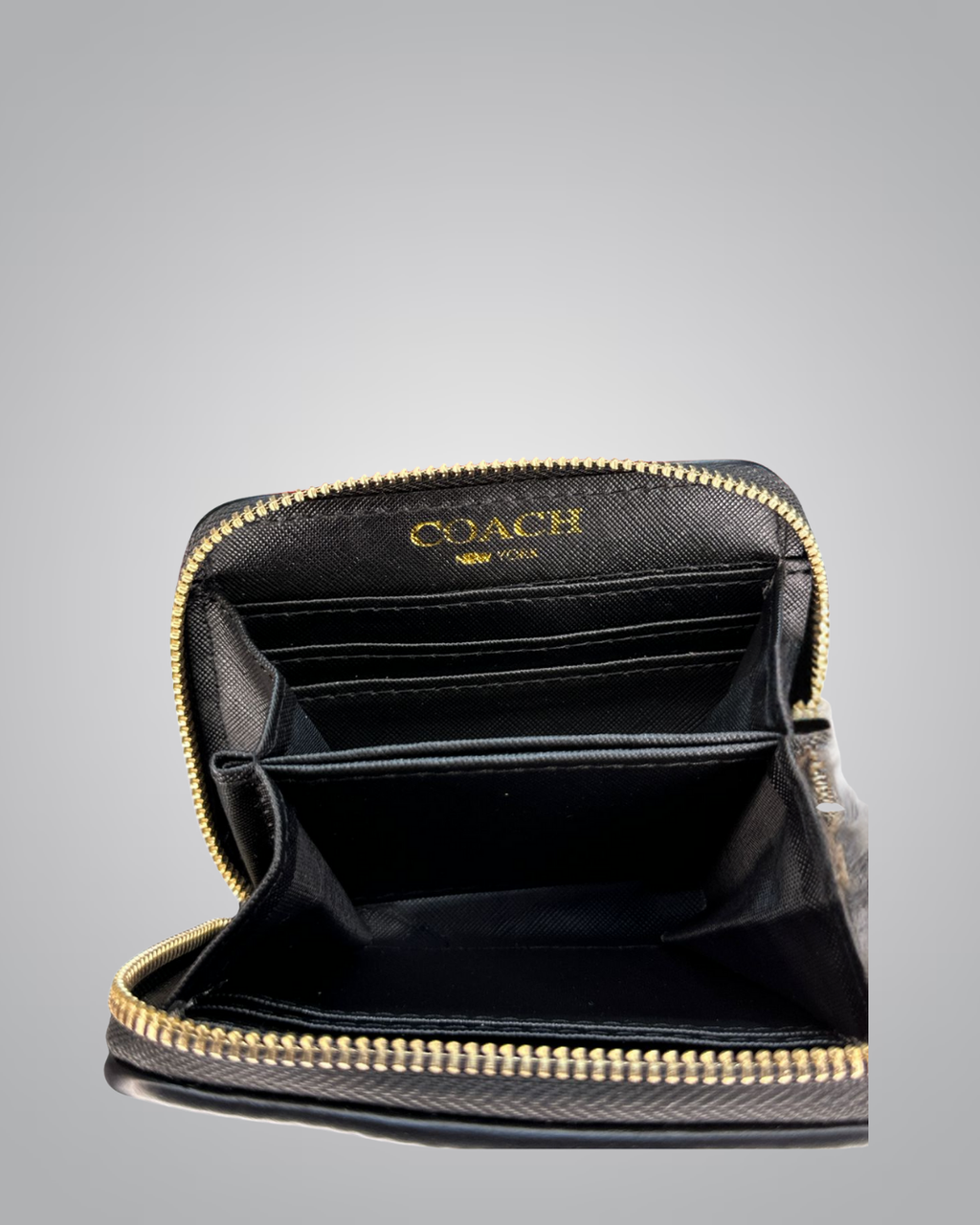 Coach wallet with gold zipper on a gray background