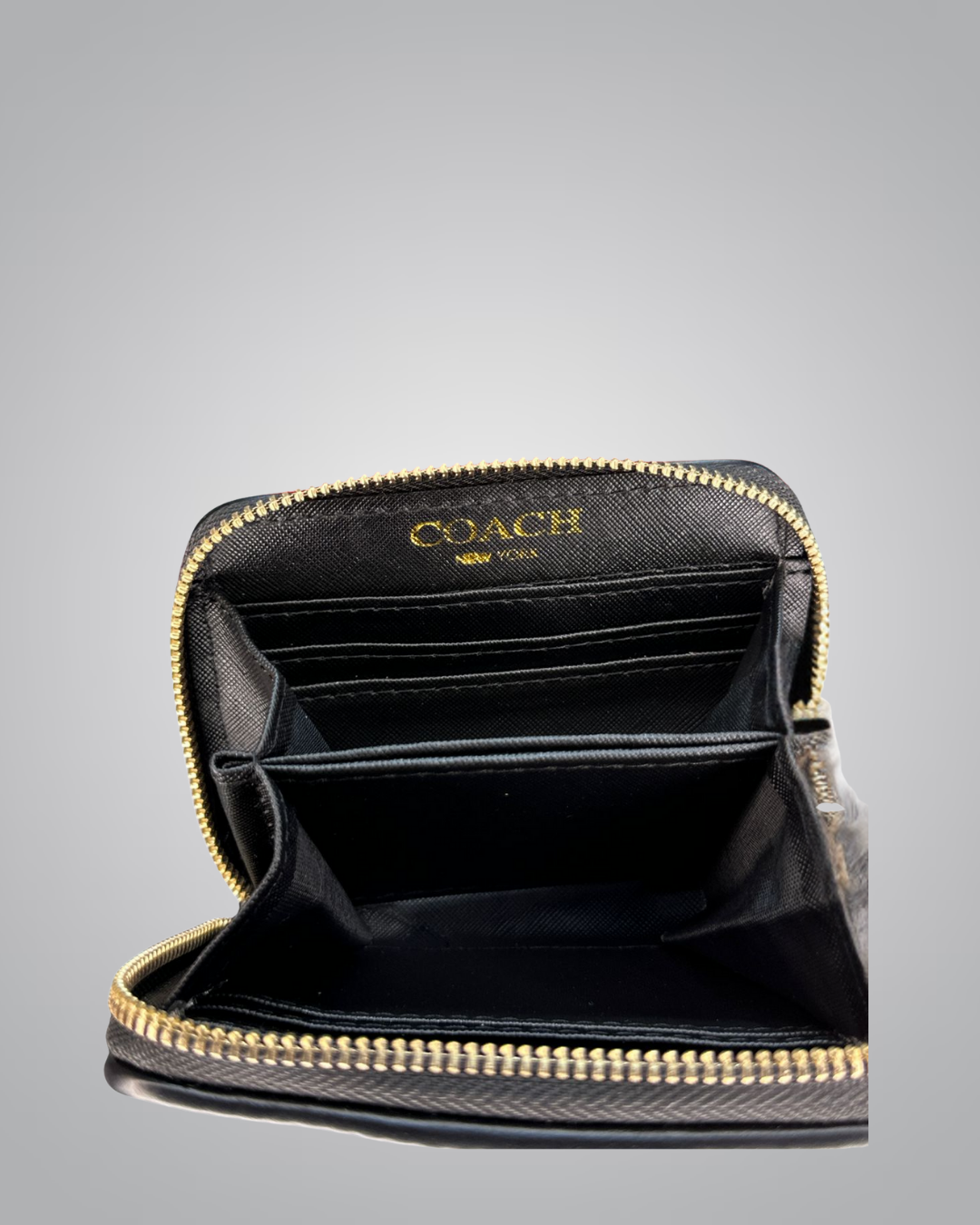 Coach wallet with gold zipper on a gray background