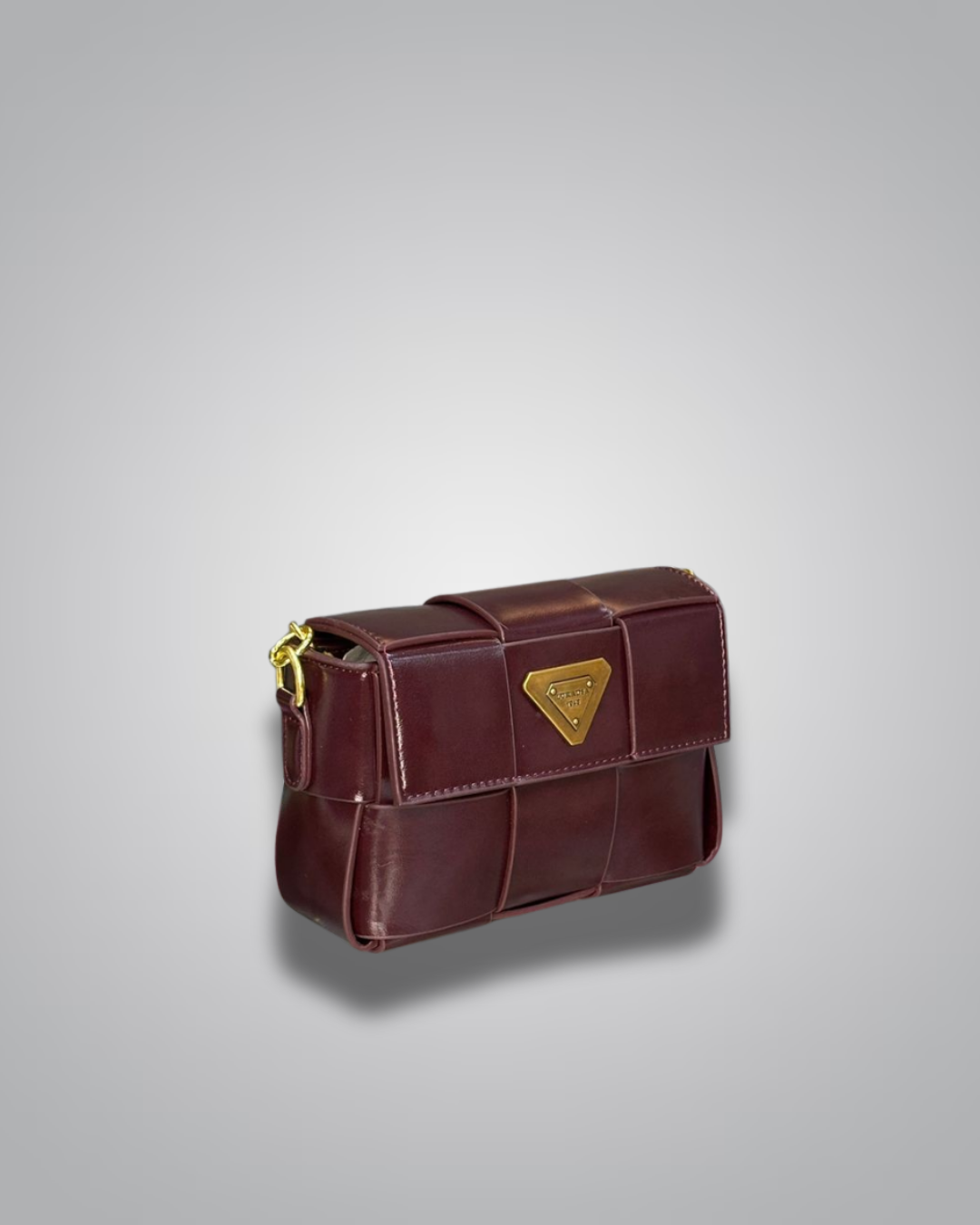 Brown leather handbag with a gold triangle emblem on a light gray background- Valentino Impex