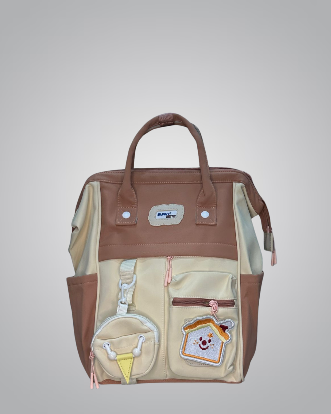Brown and beige backpack with decorative elements on a light gray background