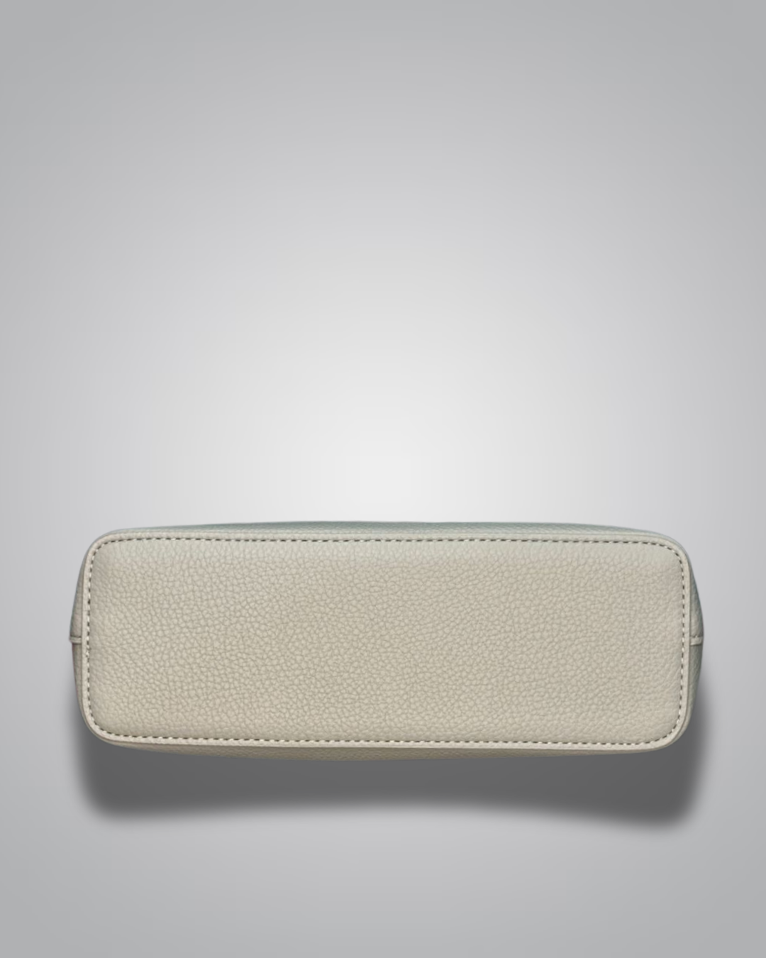 Beige handbag with a sloth keychain on a light gray background- Valentino Impex