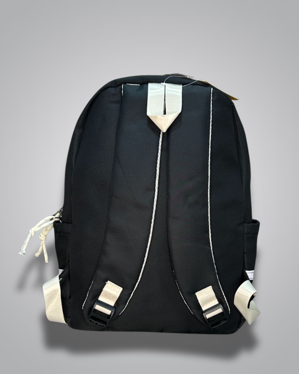 Black backpack with decorative patches and a blue star charm on a gray background- Valentino Impex