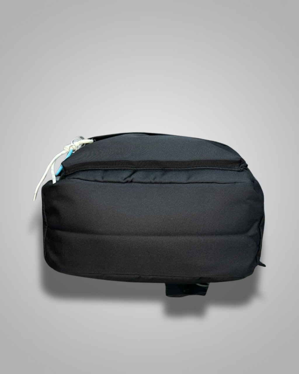 Black backpack with decorative patches and a blue star charm on a gray background- Valentino Impex