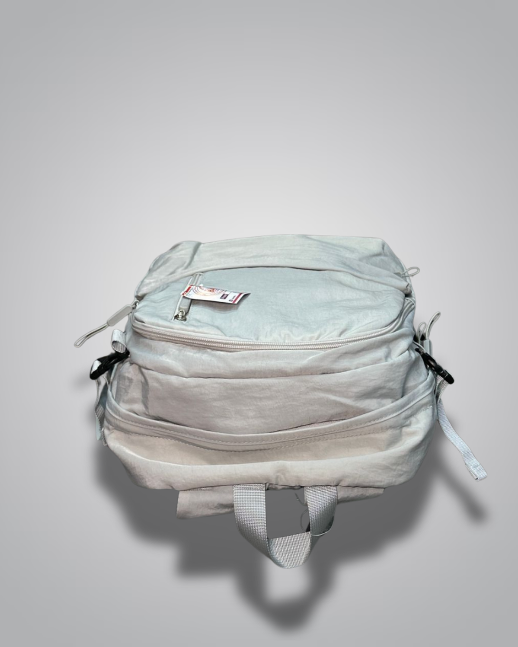 Light gray backpack with a visible brand label on a gray background- Valentino Impex