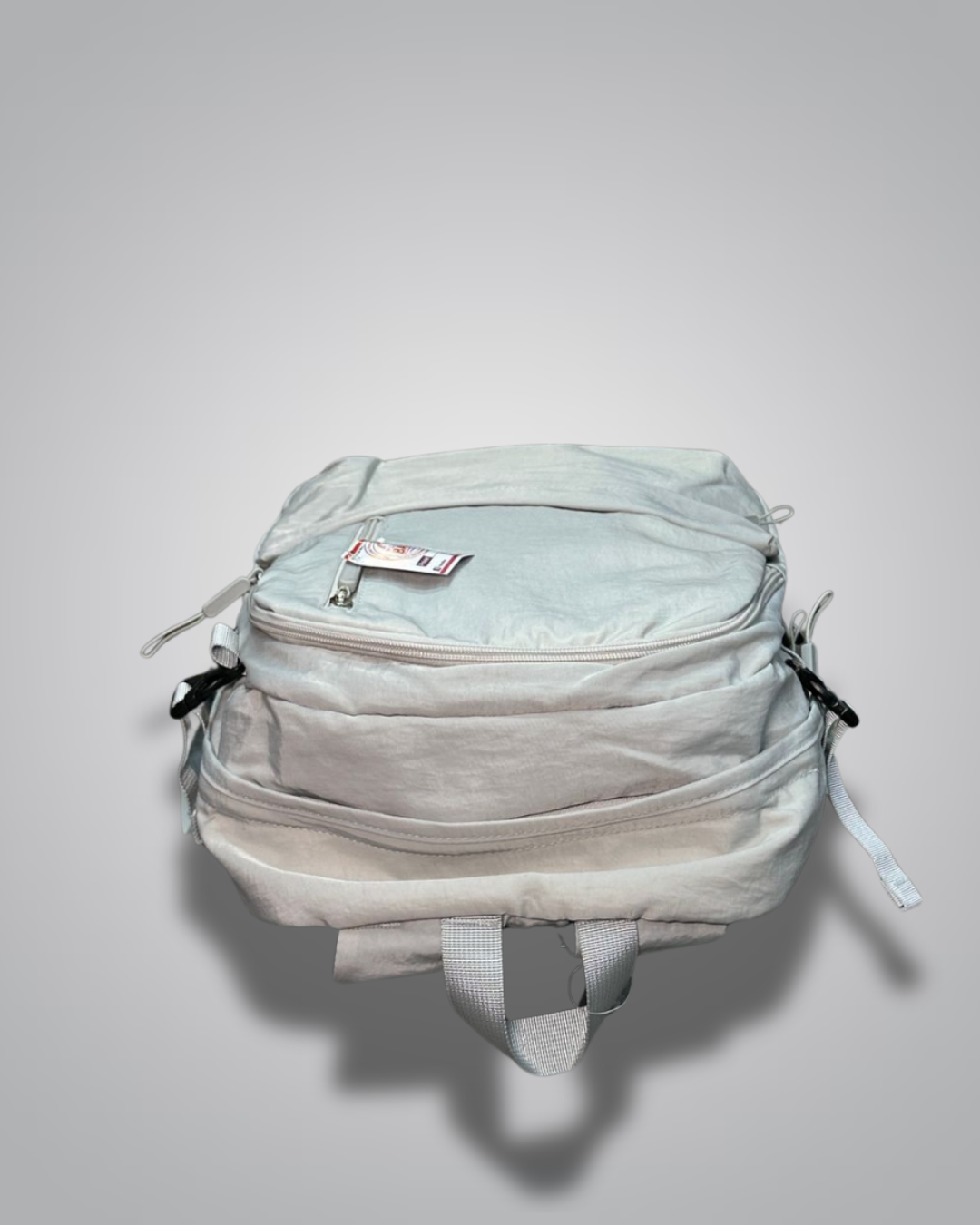 Light gray backpack with a visible brand label on a gray background- Valentino Impex