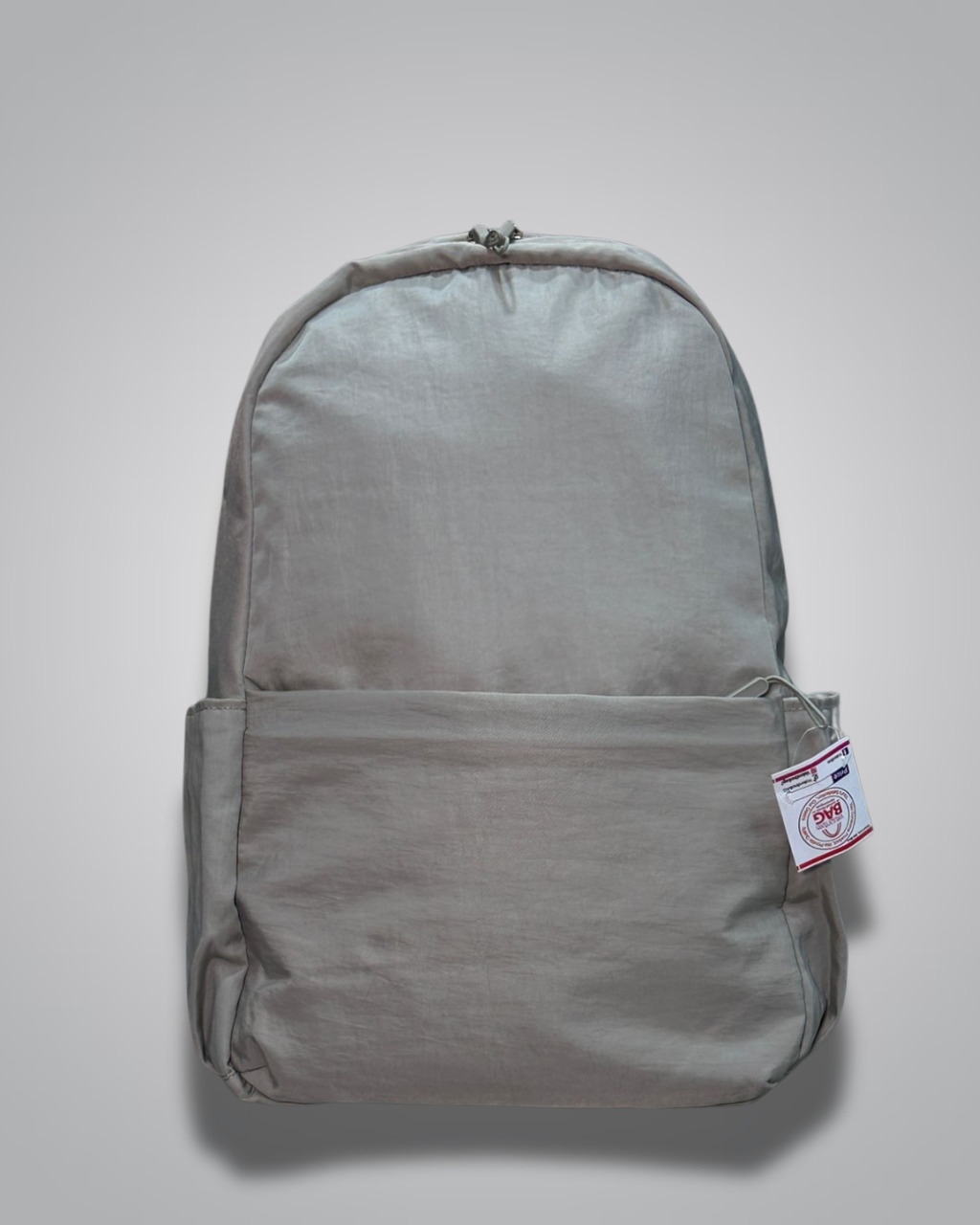 Gray backpack with a tag on a light gray background- valentini impex