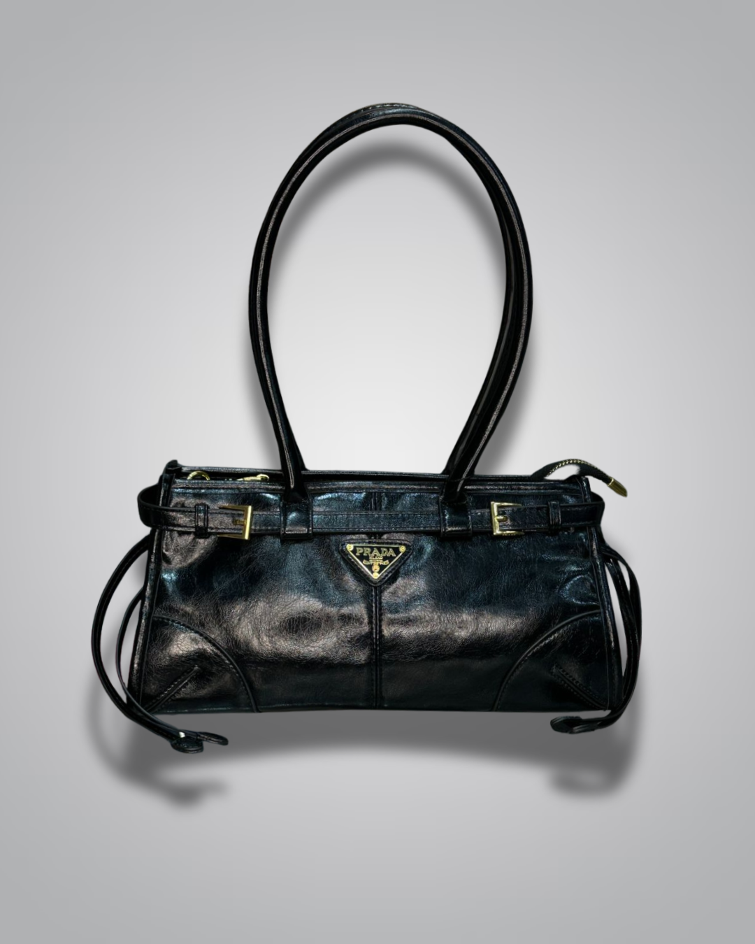 Black leather handbag with gold accents on a gray background