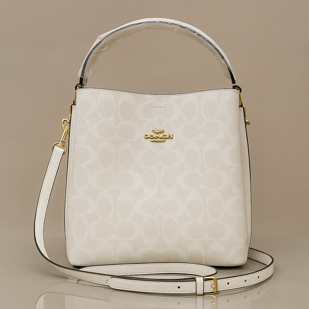 White handbag with gold accents on a beige background