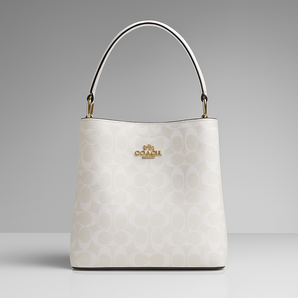 White handbag with gold handle on a gray background