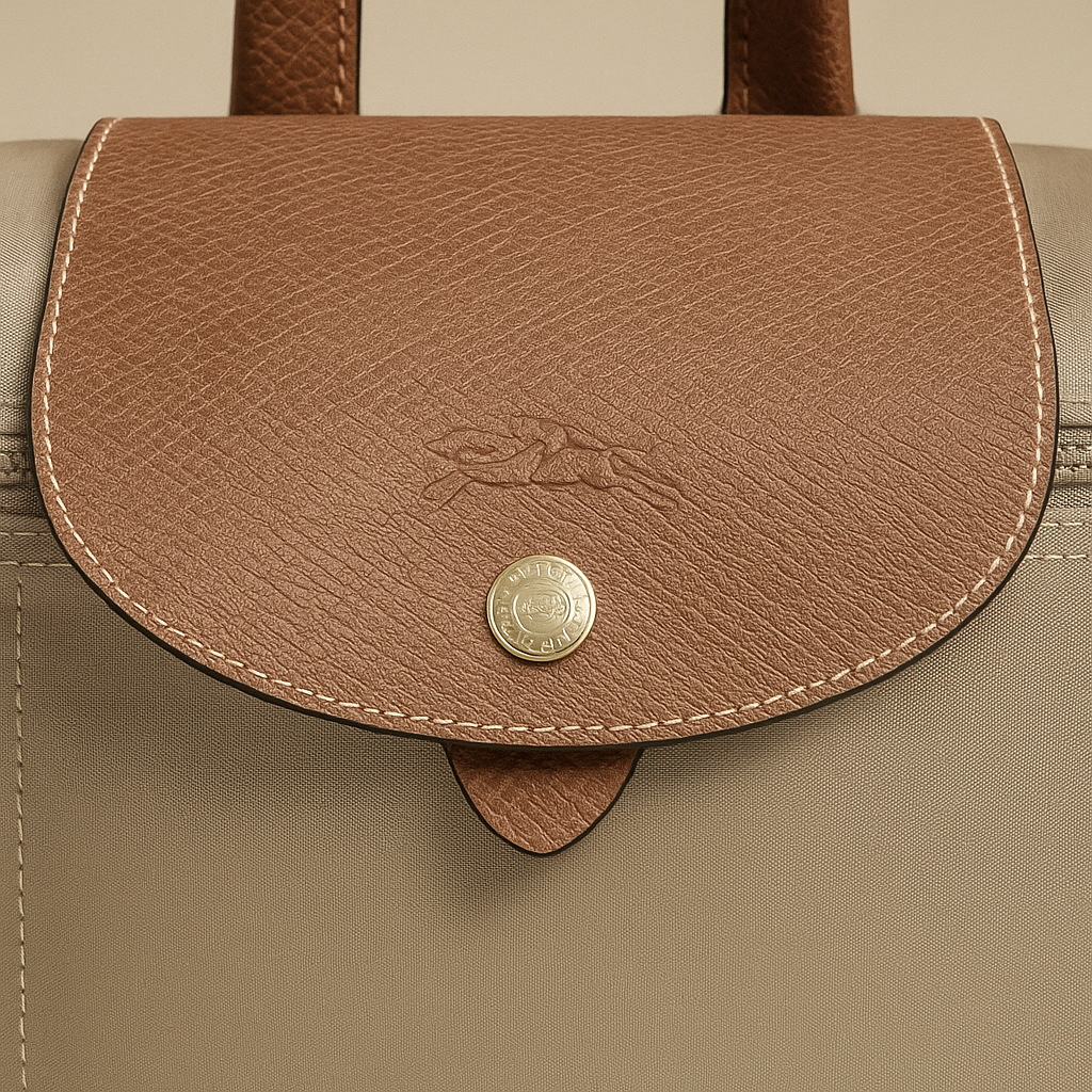 Close-up of a brown leather flap on a beige bag with a brand logo- valentino impex